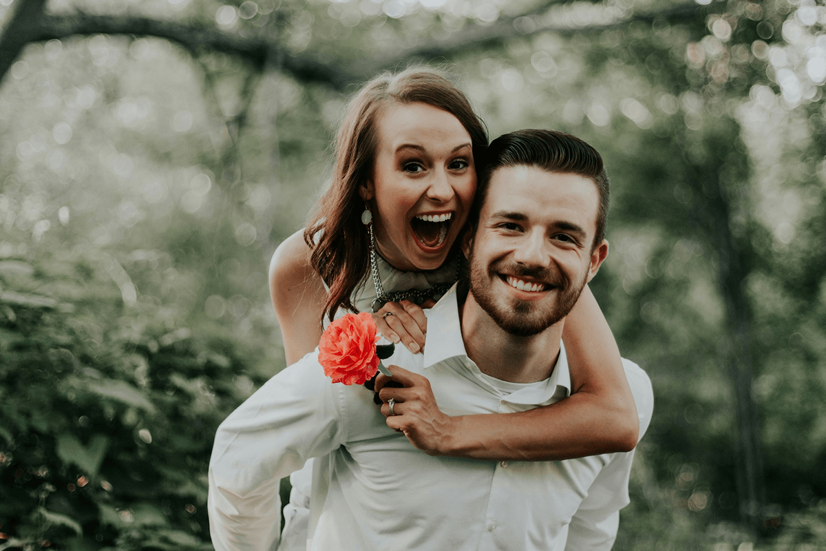 Two friends looking up at a bright blue sky, framing the moment with their hands