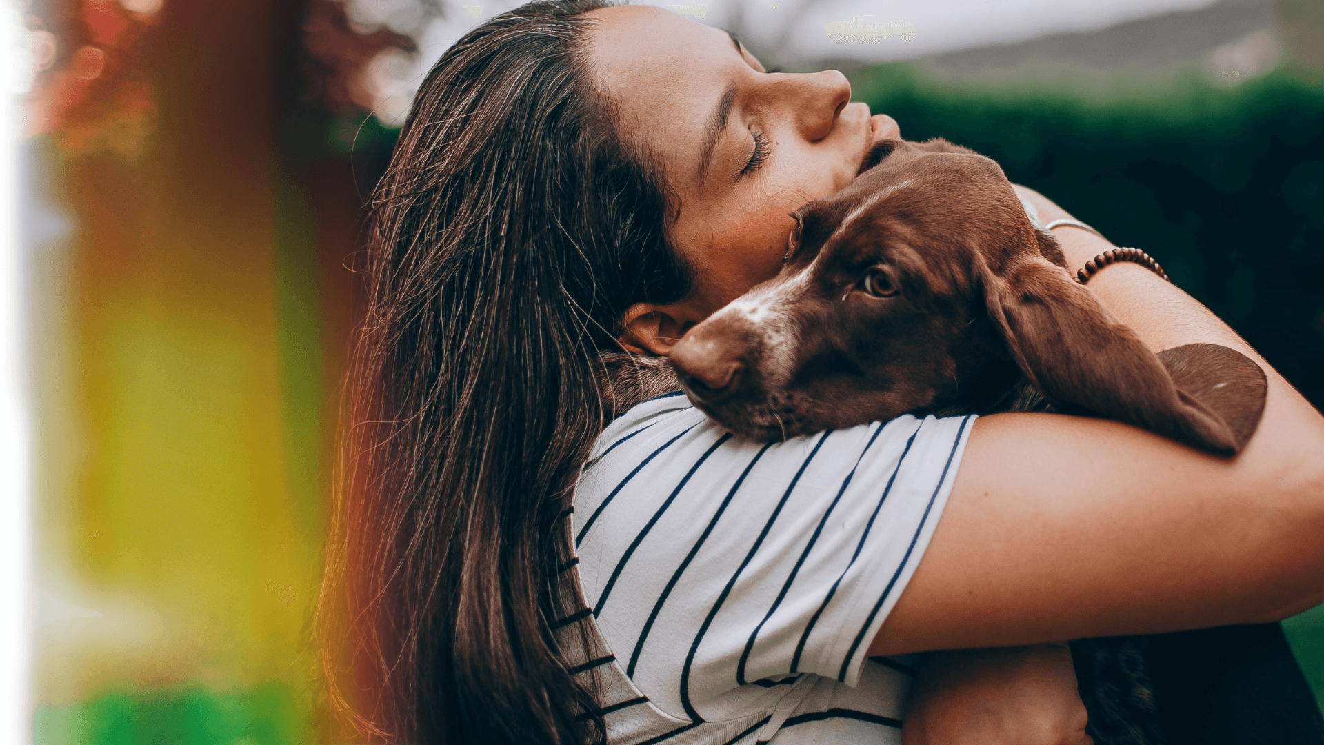 A member embracing her dog outdoors